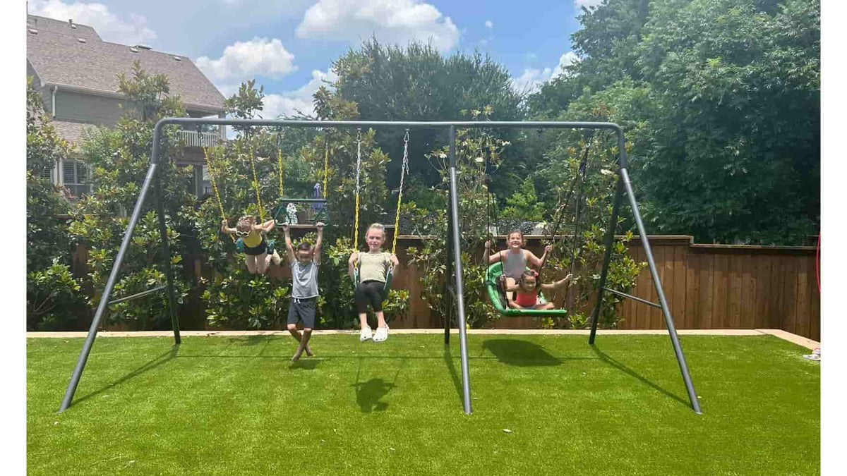 Five kids swinging on a swing set.
