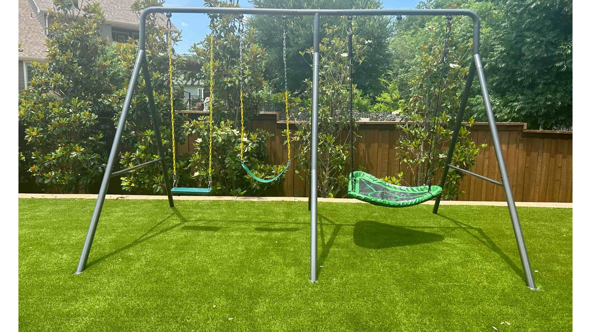 A medium-sized metal swing set with three swings.